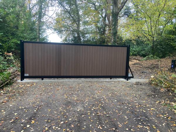 Sliding driveway gate clad in composite boards